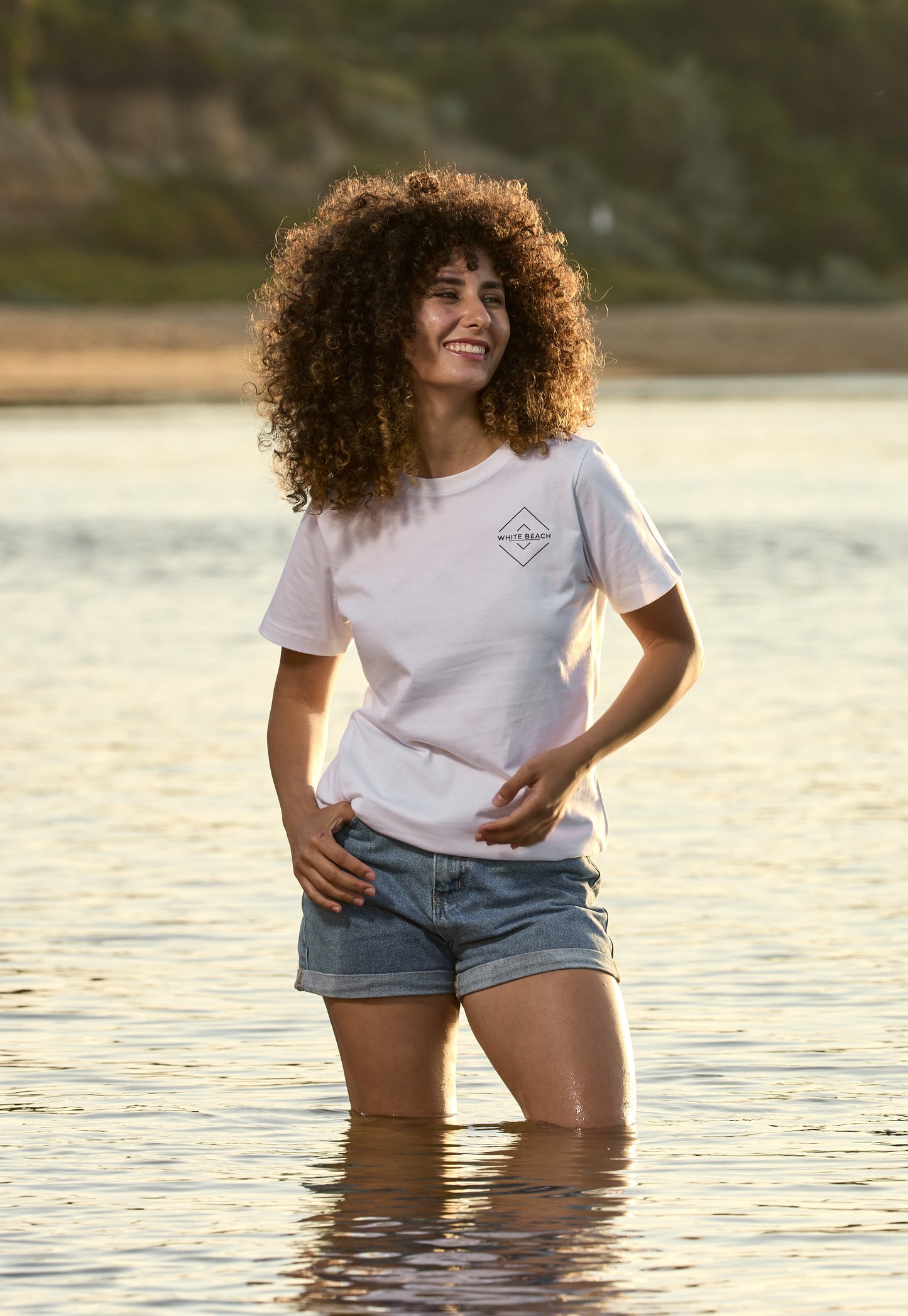 Woman in premium short sleeve tee at beach, showcasing casual style and comfort.