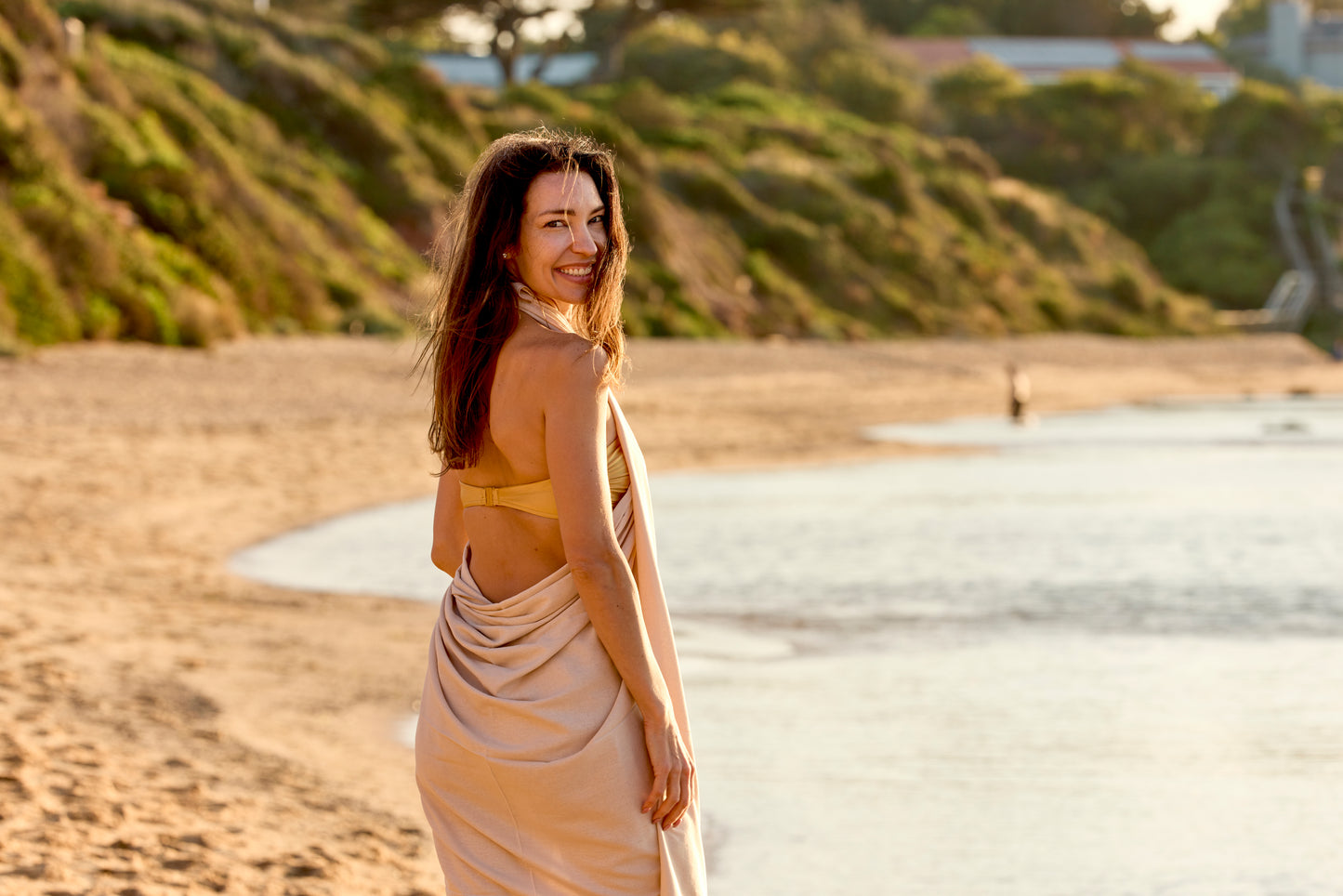 Woman on beach with ivory ramie beach sheet.